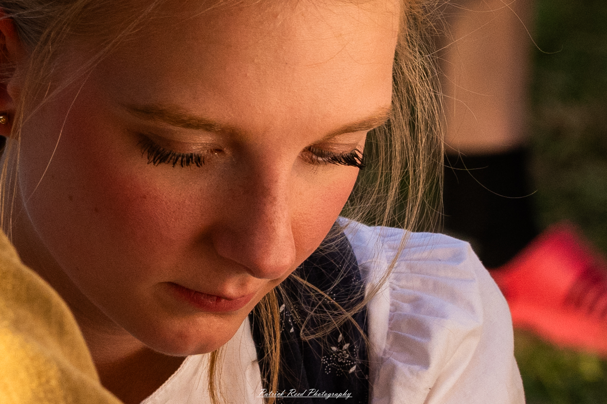 "Close-up portrait of a young female medic with blonde hair, wearing a WWII-era uniform and medical insignia. Her expression is focused and determined, reflecting the intensity of her role during the war. The background is softly blurred, emphasizing her features and the medical gear she's equipped with, highlighting the critical support that medics provided on the battlefield."